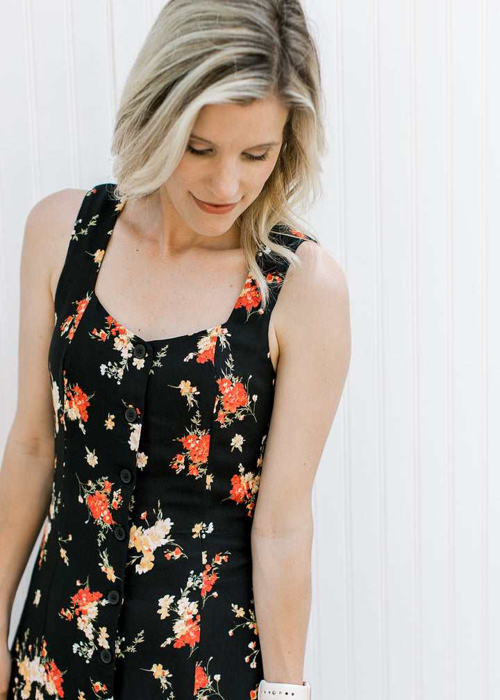 Close up of sweetheart neckline and a button front on a black sleeveless maxi with bright floral. 