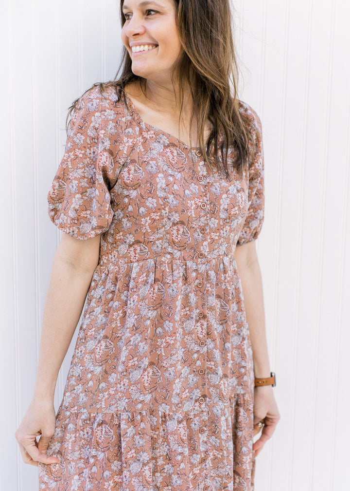 Close up of bubble short sleeves and button front on a burgundy dress with blue and cream floral.