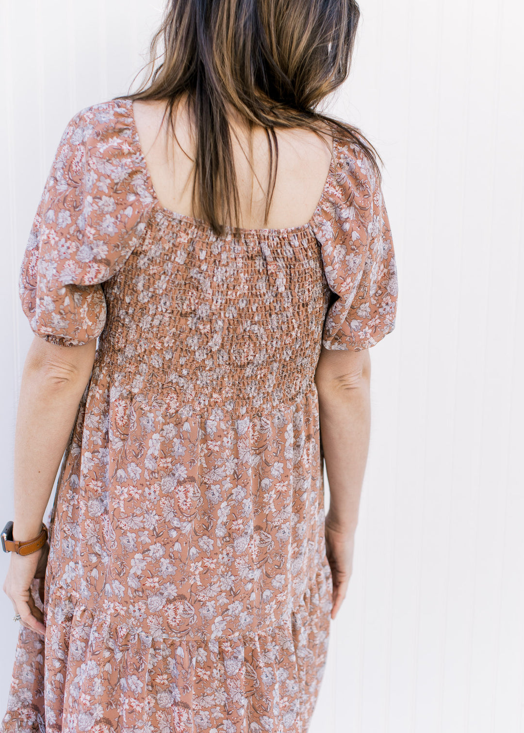Back view of square neck and smocked back on a burgundy dress with blue and cream flowers.