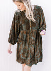 Model wearing an above the knee green velvet dress with brown floral and 3/4 batwing sleeves.