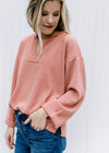 Model wearing an v-neck apricot top with a cuffed sleeve and patchwork detail.