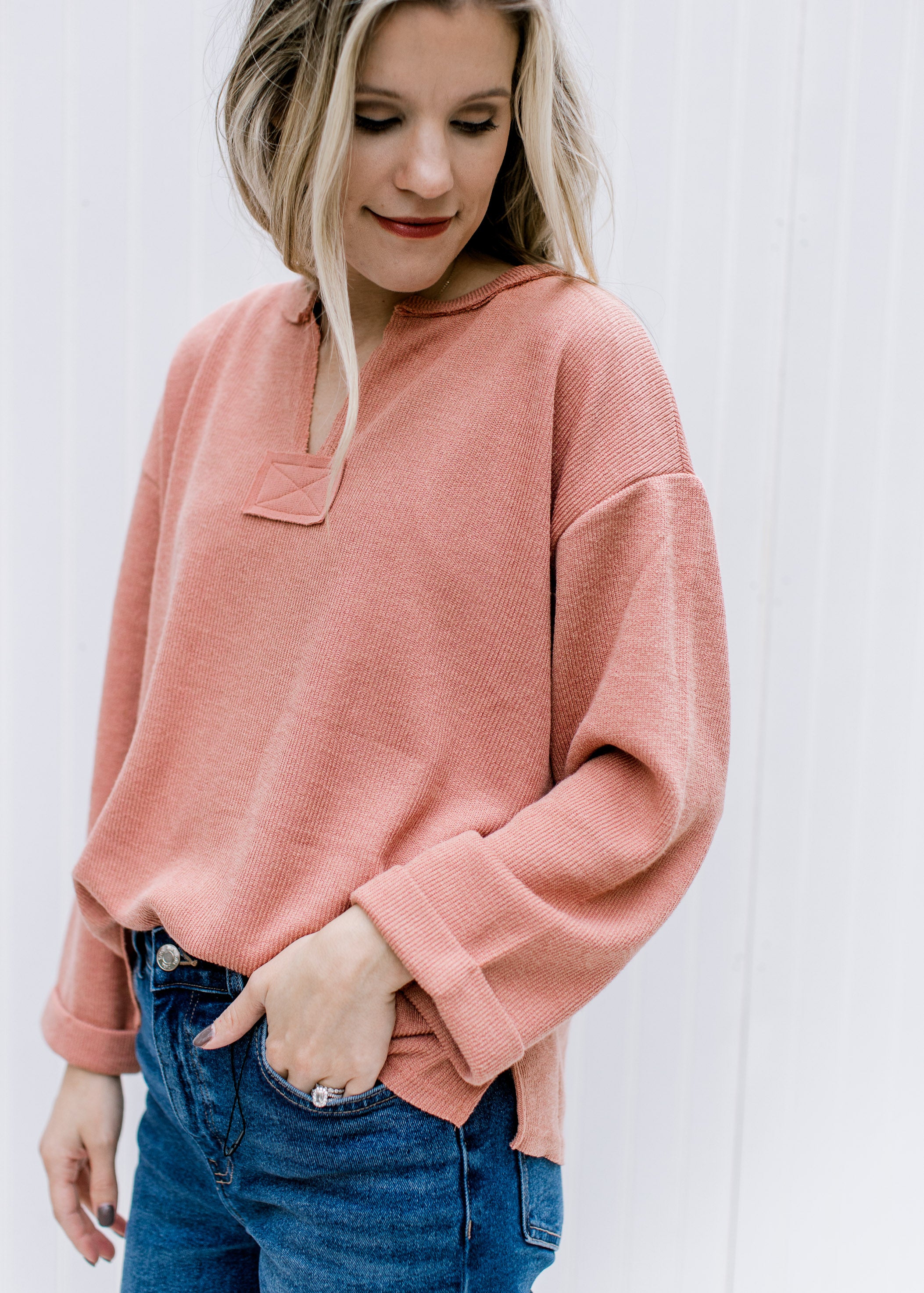 Model wearing an v-neck apricot top with a cuffed sleeve and patchwork detail.