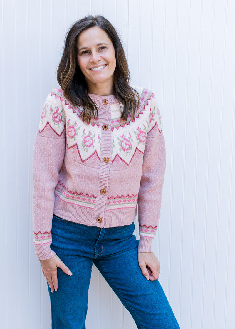 Model wearing a dusty pink button up sweater with fair isle pattern at yolk and long sleeves.