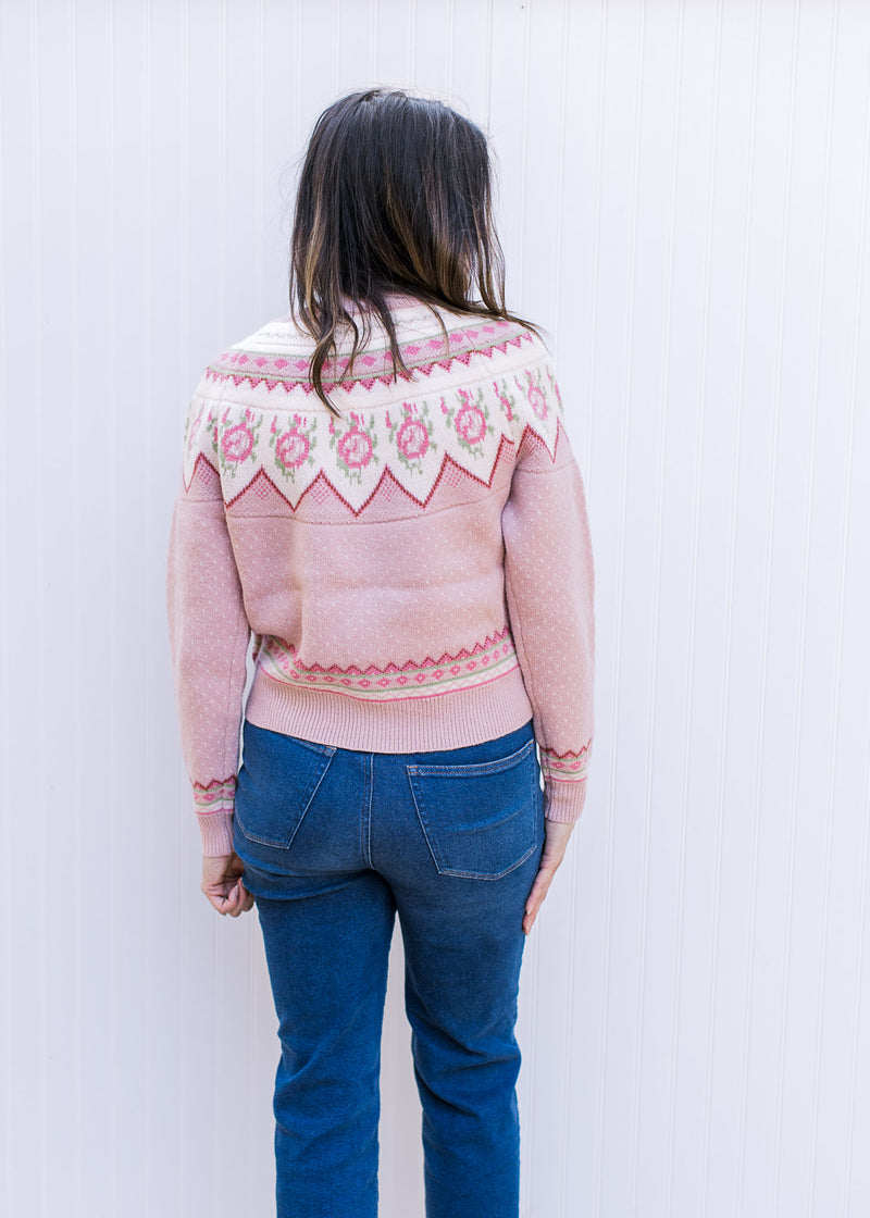 Back view of Model wearing a dusty pink button up sweater with fair isle pattern and long sleeves.