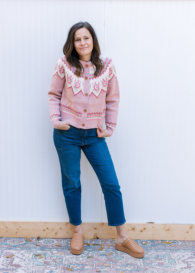 Model wearing jeans, mules and a dusty pink button up sweater with fair isle pattern at yolk.