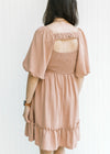 Model wearing a mauve above the knee dress with a ruched strap, smocked back and bubble sleeves.