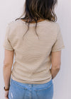 Back view of Model wearing a ecru and camel crew neck tee with stripes and short sleeves. 