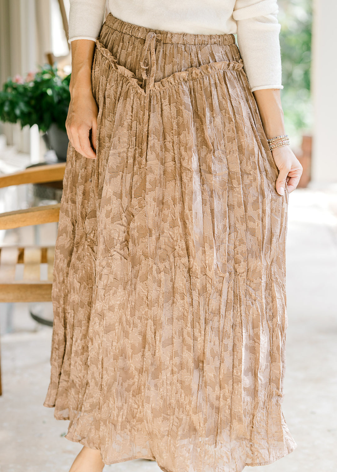 Model wearing a toffee midi with subtle lace, v-shaped ruffle at the waist and elastic band. 