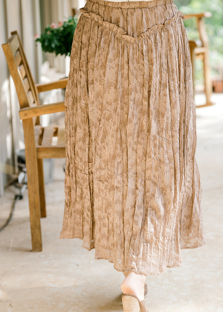 Back view of Model wearing a toffee midi with lace, v-shaped ruffle at waist and elastic band. 