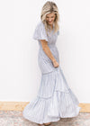 Model wearing a white maxi with a pale blue print, short sleeves and a wide elastic waist. 