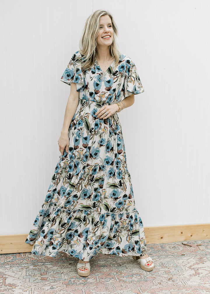 Model wearing a lined, cream v-neck maxi with watercolor floral, short sleeves and elastic waist. 