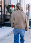 Back view of Model wearing a knit olive green sweater with bubble long sleeves. 