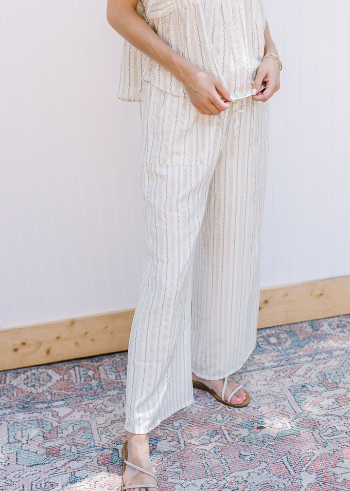 Close up of wide leg bottoms with pockets and green and tan stripes, it comes with matching top. 