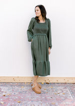 Model wearing an evergreen dress with bubble long sleeves, square neck and pockets.