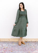 Model wearing mules and an evergreen dress with bubble long sleeves, square neck and pockets.