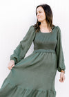 Close up flowy skirt on an evergreen dress with bubble long sleeves and a square neck.