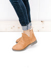 Model wearing jeans with a tan bootie lined with faux fur, having a side zip and a 3.5 inch shaft. 