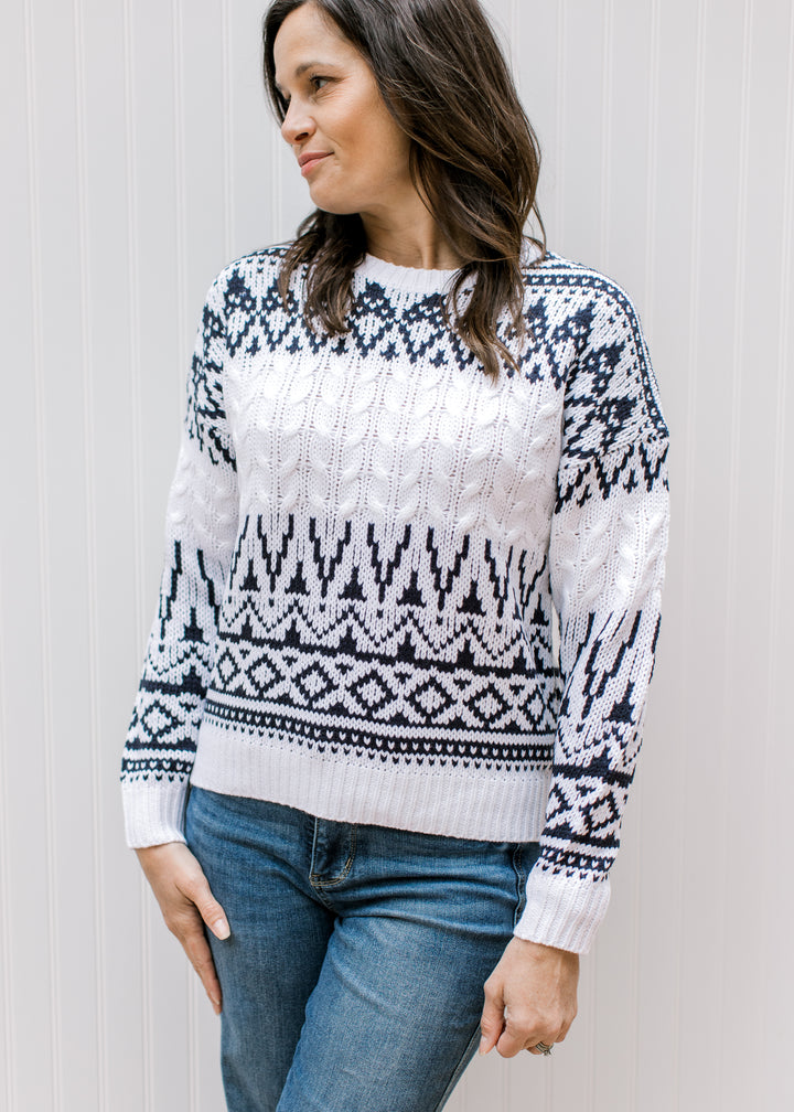 Model wearing a cream knit sweater with a navy Fair Isle design, round neck and long sleeves. 