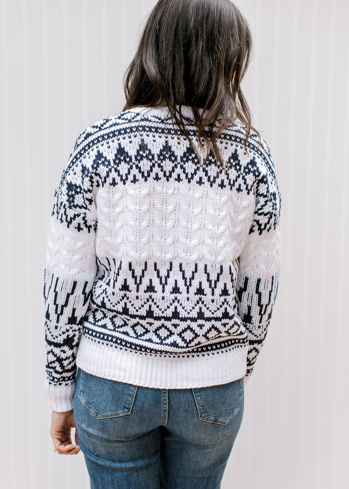 Back view of Model in a cream sweater with a navy Fair Isle design, round neck and long sleeves. 