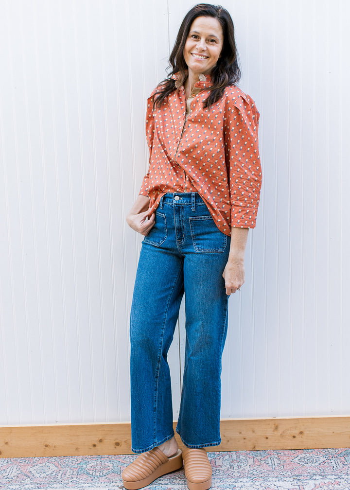 Model wearing mules, jeans and a button up rust top with soft yellow floral and 3/4 sleeve.