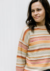 Close up of textured sweater with striped fall colors, long sleeves and a round neck. 