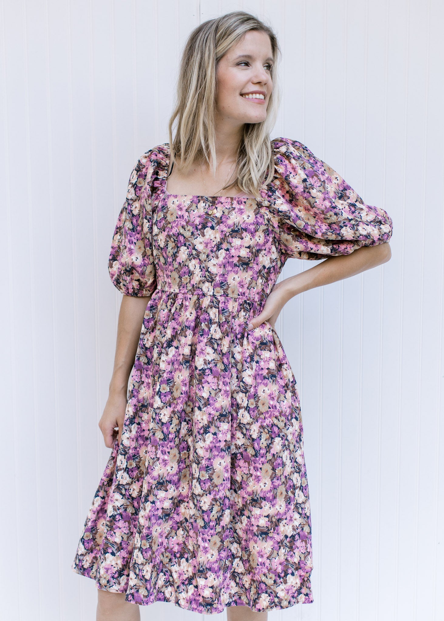 Model wearing a floral corduroy dress with a square neckline, smocked back and bubble short sleeves.