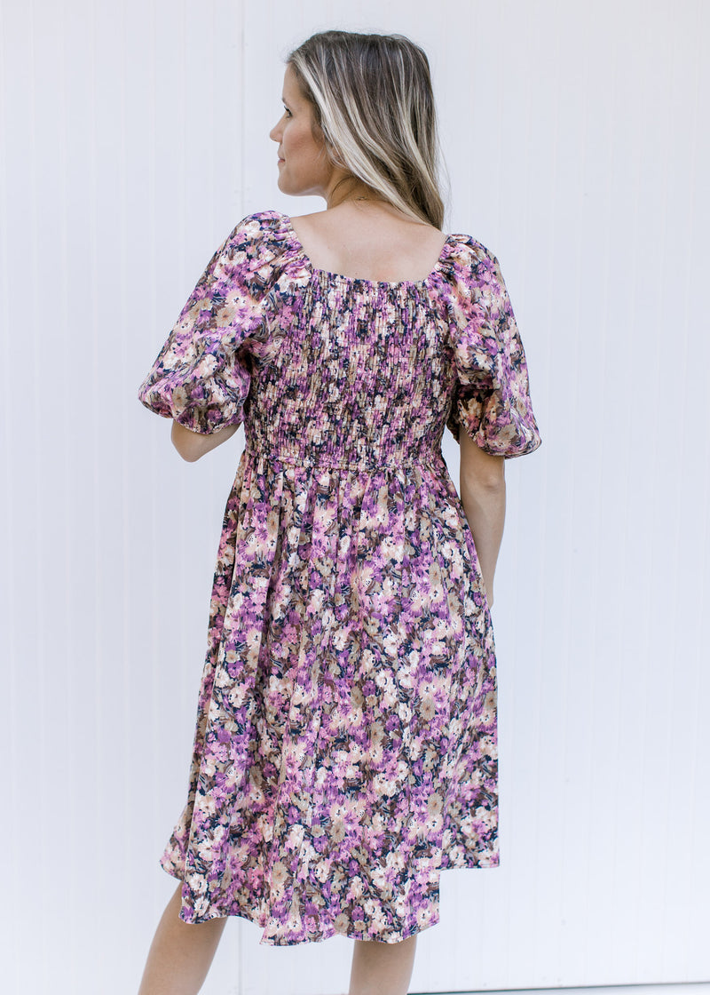 Back view of Model wearing a floral corduroy midi dress with a square neckline and a smocked back.