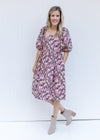 Model wearing booties with a floral dress with a square neck, smocked back and bubble short sleeves.