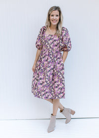 Model wearing booties with a floral dress with a square neck, smocked back and bubble short sleeves.
