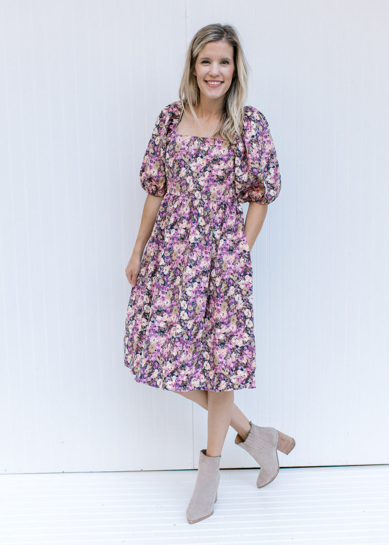 Model wearing booties with a floral dress with a square neck, smocked back and bubble short sleeves.