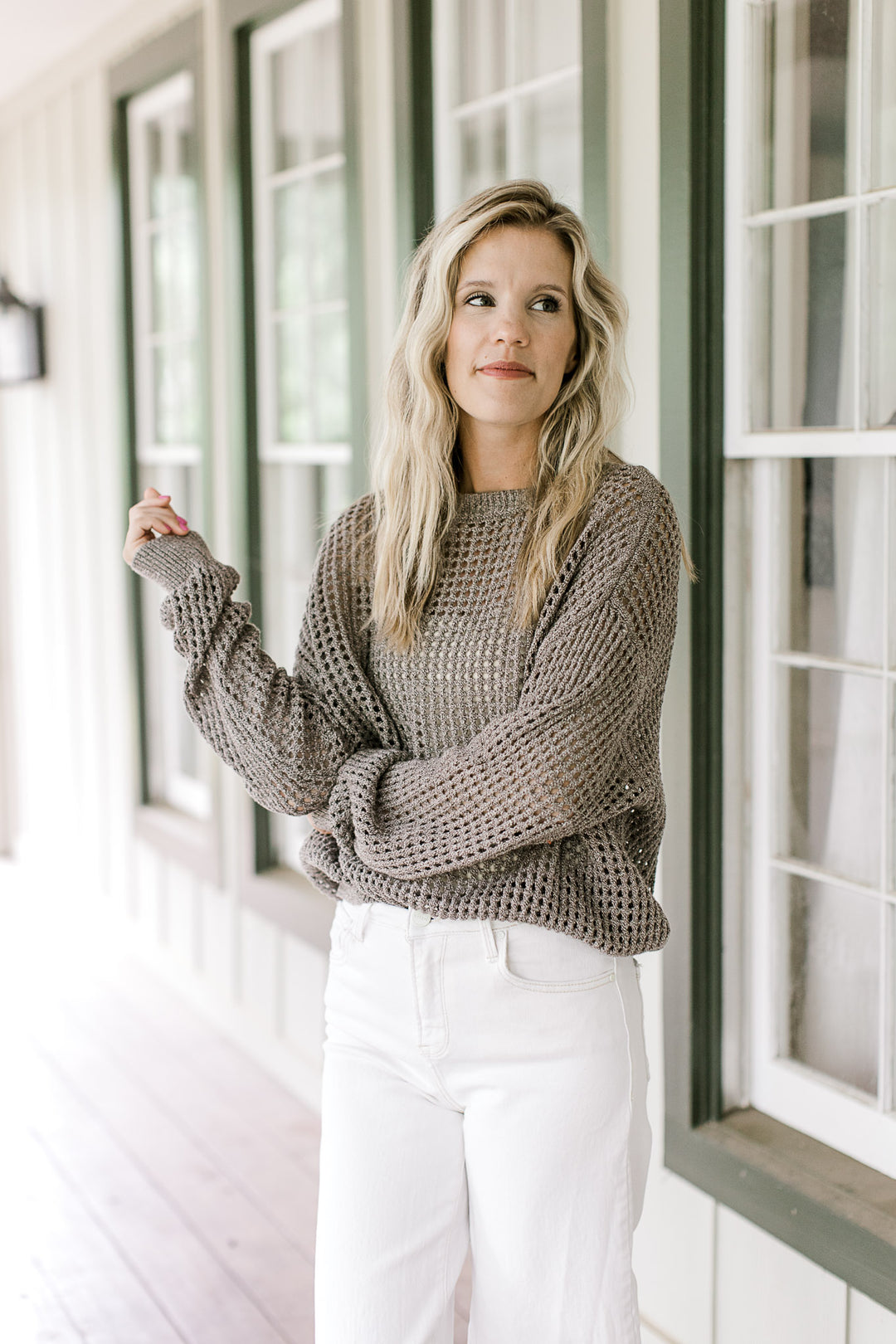 Model wearing a brown loose knit sweater with long sleeves and a round neck.