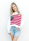 Model wearing shorts and a white knit sweater with a flag pattern, crew neck and long sleeves.