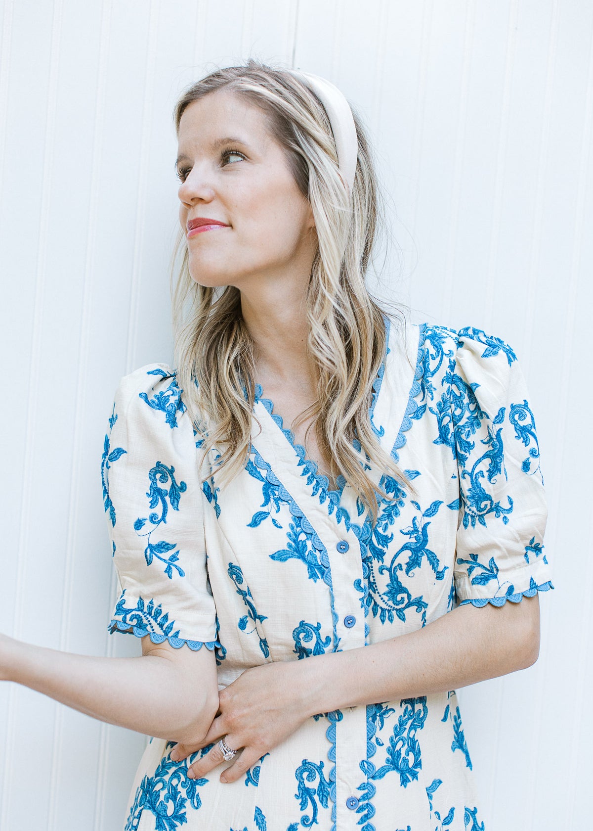 Close up of scalloped lace detail on a v-neck cream midi with blue floral pattern and short sleeves.