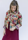 Model wearing a red dress with a floral tapestry jacket with a button closure and a crop fit.