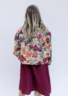Back view of Model wearing a floral tapestry jacket with a button closure and a crop fit.