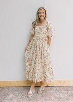 Model wearing wedges with a pink and yellow flowers, pleated bust and short sleeves.