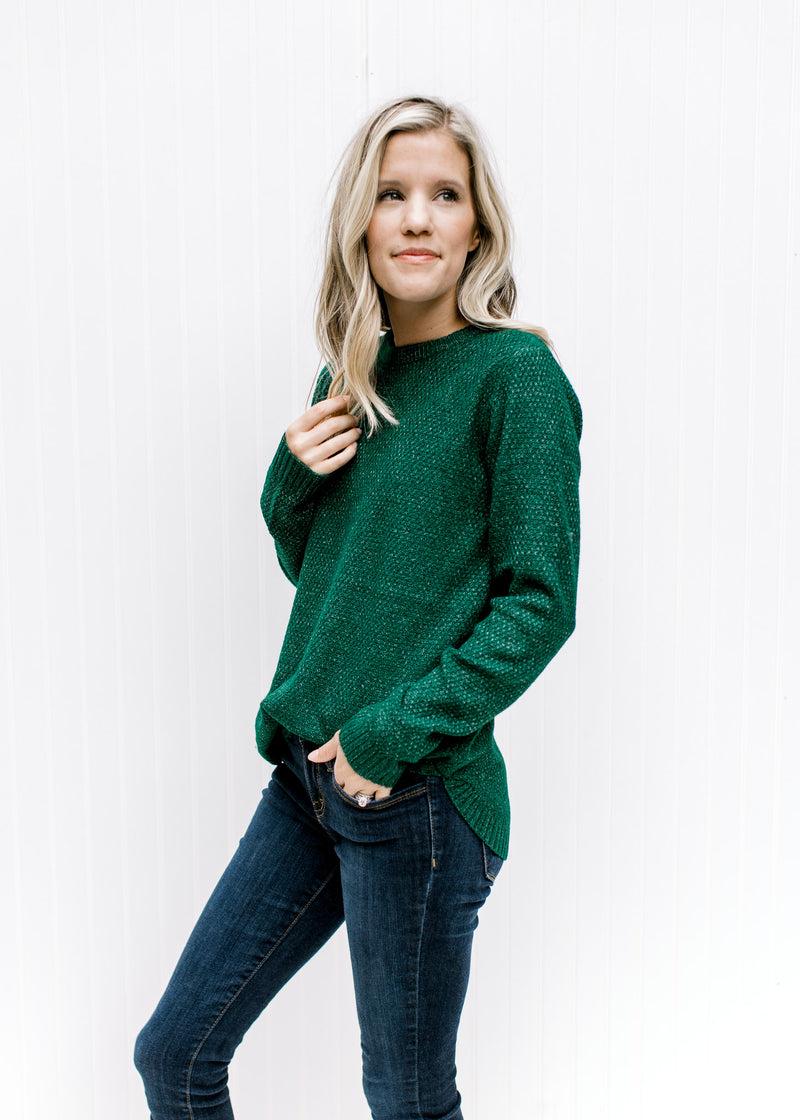 Model wearing a forest green sweater with a textured material, long sleeves and a crew neckline. 