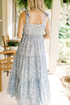 Back view of Model wearing a white midi with light blue floral, tie spaghetti straps and a zipper. 