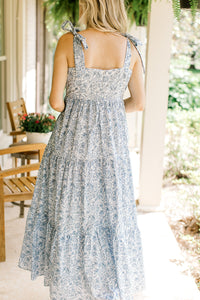 Back view of Model wearing a white midi with light blue floral, tie spaghetti straps and a zipper. 