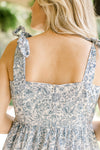 Close up of square neck and zipper on back of a white midi with blue floral and a zip closure. 