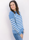 Model wearing a light blue long sleeve sweater with cream stripes ribbed neck, cuff and hem.