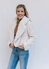 Model wearing a camel top  ivory open front coat with a crop cut, pockets and long sleeves. 