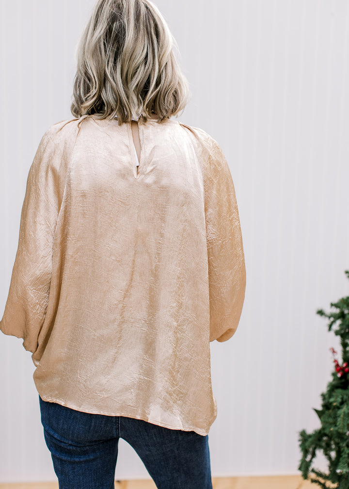 Back view of Golden Shimmer Top showing keyhole neckline, loose drape, bubble sleeves and shimmering gold fabric.