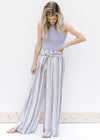 Model wearing striped pants with a ribbed gray sleeveless body suit with a mocked neckline. 