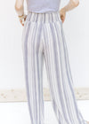 Back view of model wearing gray and white striped wide leg pants with elastic on the back. 