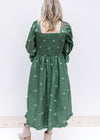 Back view of smocked back and square neckline on a green midi with cream embroidered bows. 