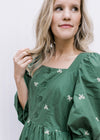 Close up of square neck on a green midi with cream embroidered bows and 3/4 poet sleeves. 