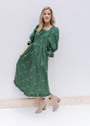 Model wearing booties and a green midi with cream embroidered bows, a square neck and 3/4 sleeves. 