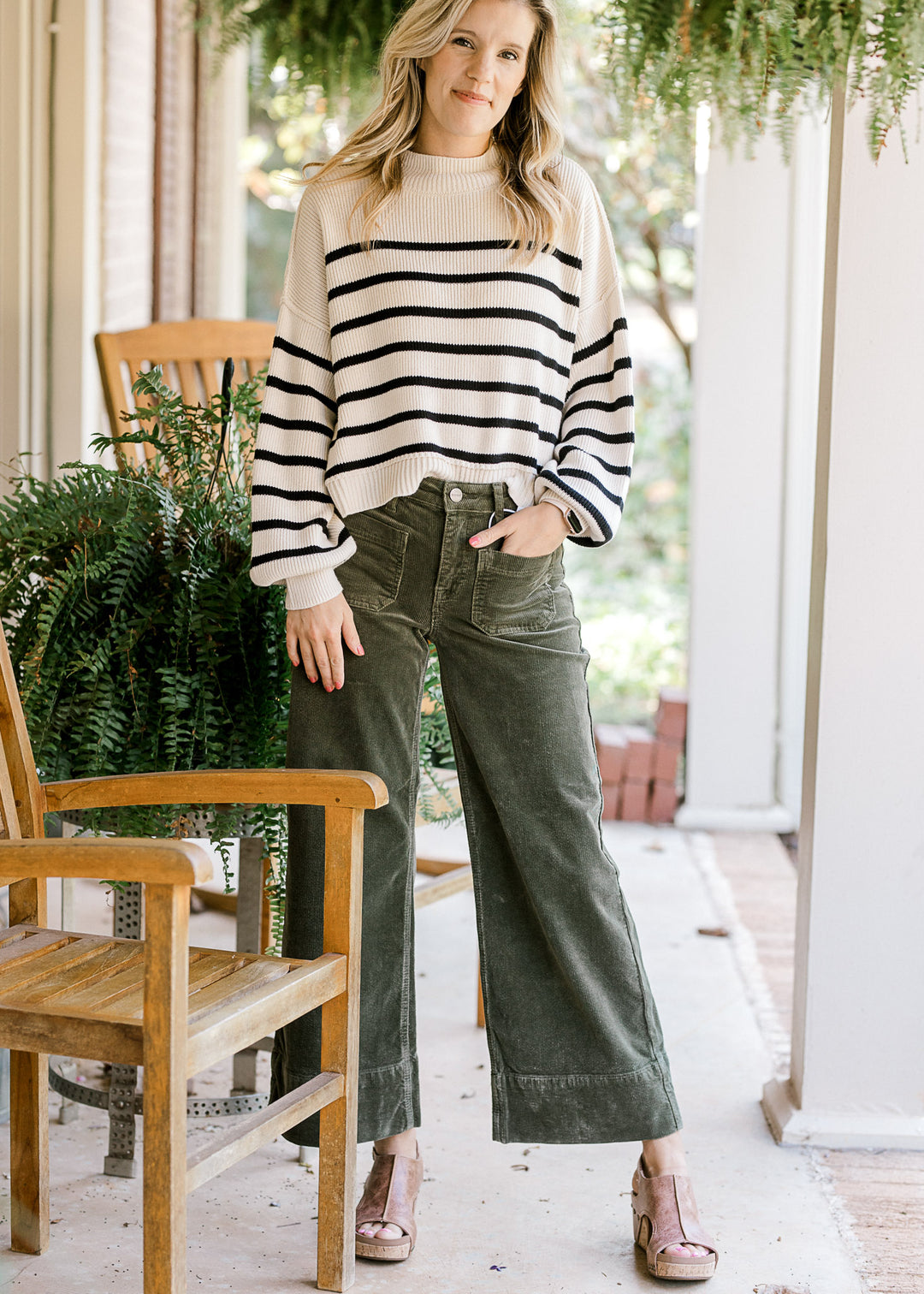Model wearing green corduroy cropped pants with front patch pockets and traditional button. 