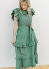 Model wearing a deep green midi with ruffle collar, sleeves and double ruffles on skirt.